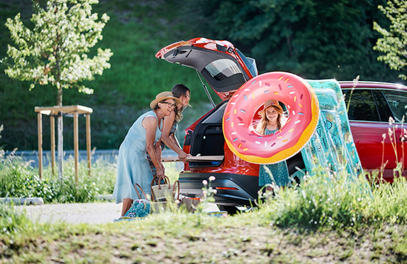 A family loading their rental car with swimming gear.