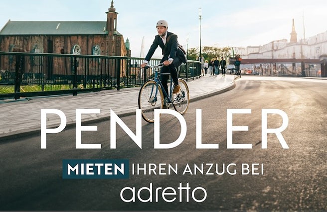 Ein Fahrradfahrer f&auml;hrt im Anzug auf der Strasse.